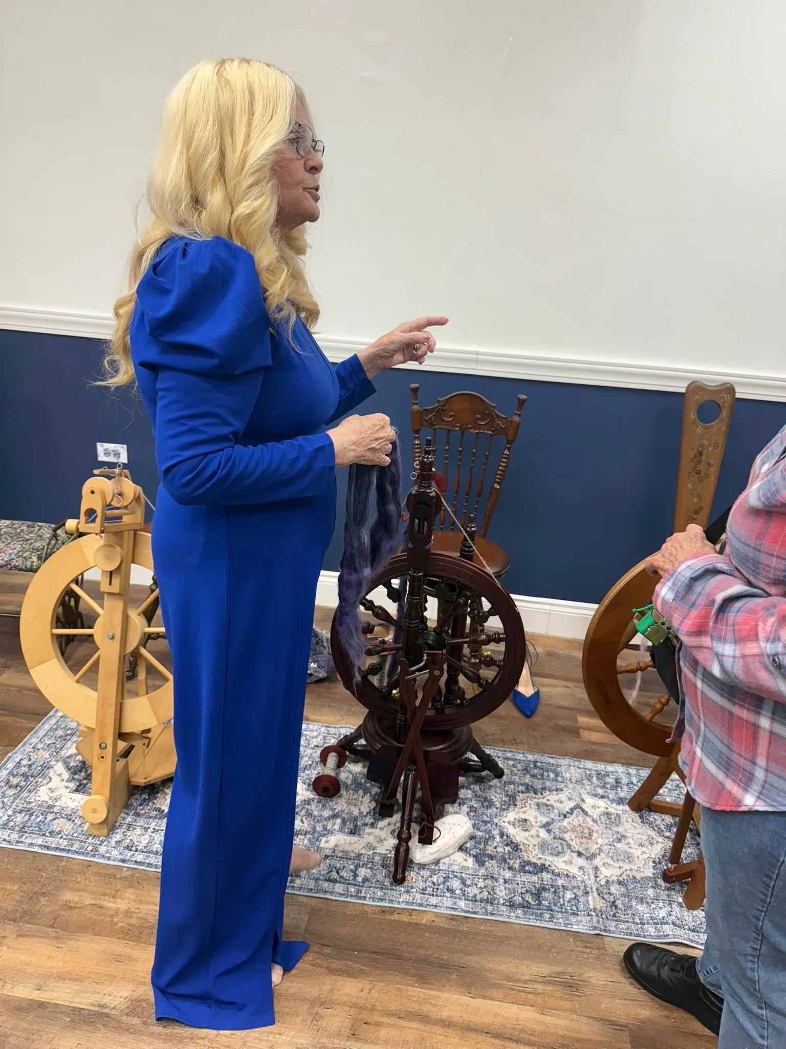 Susan beside a row of spinning wheels